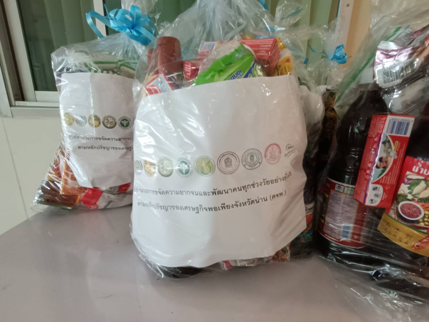 พช.น่าน : ศจพ.จ.น่าน มอบสิ่งของเครื่องอุปโภค/บริโภค แก่สำนักงานพัฒนาชุมชนอำเภอ เพื่อนำไปมอบแก่ครัวเรือนยากจน ที่ตกเกณฑ์ TPMAP